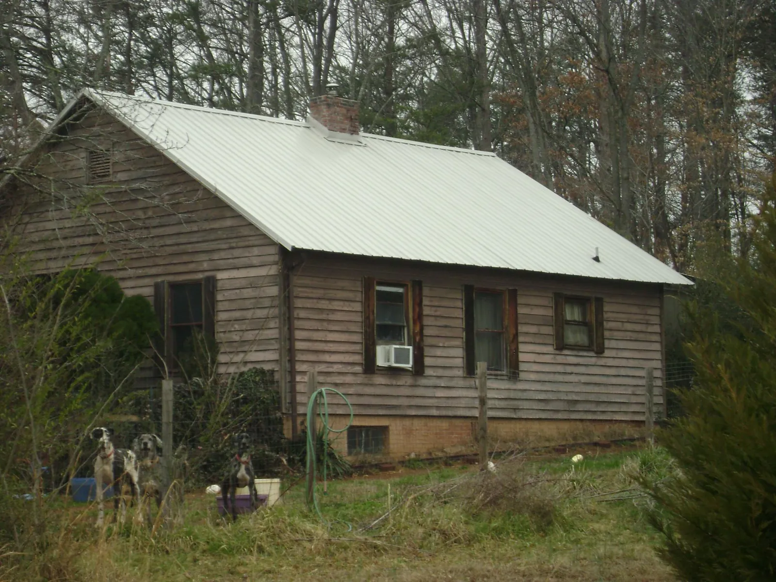 White metal roof on an old wood sided farmhouse, from a Metal Roof Installation job in Poulan